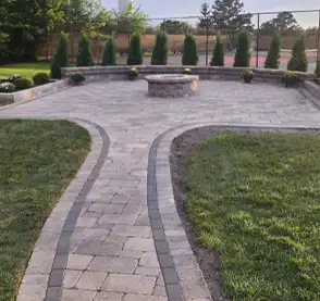 A large beautiful paver patio, with a paver path leading to it.