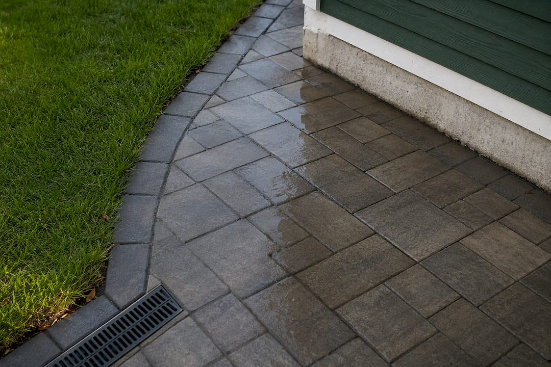 Settled pavers directing water toward foundation